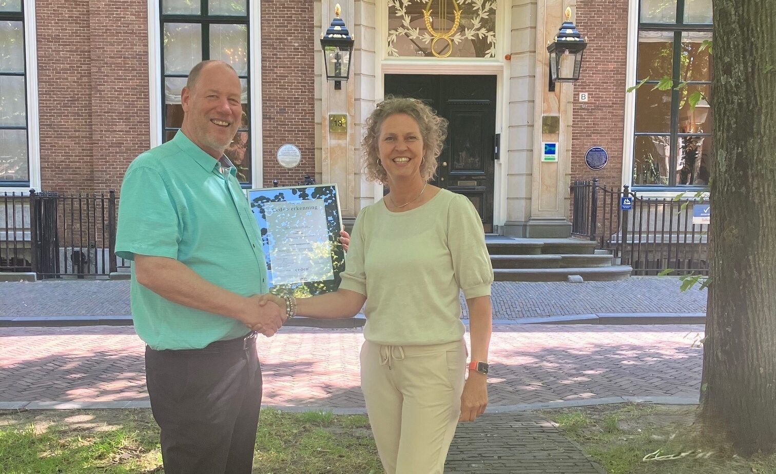 Medezeggenschapstrainer Marco Sikkel krijgt het certificaat van de Cedeo-erkenning overhandigd van Nathalie de Bok.